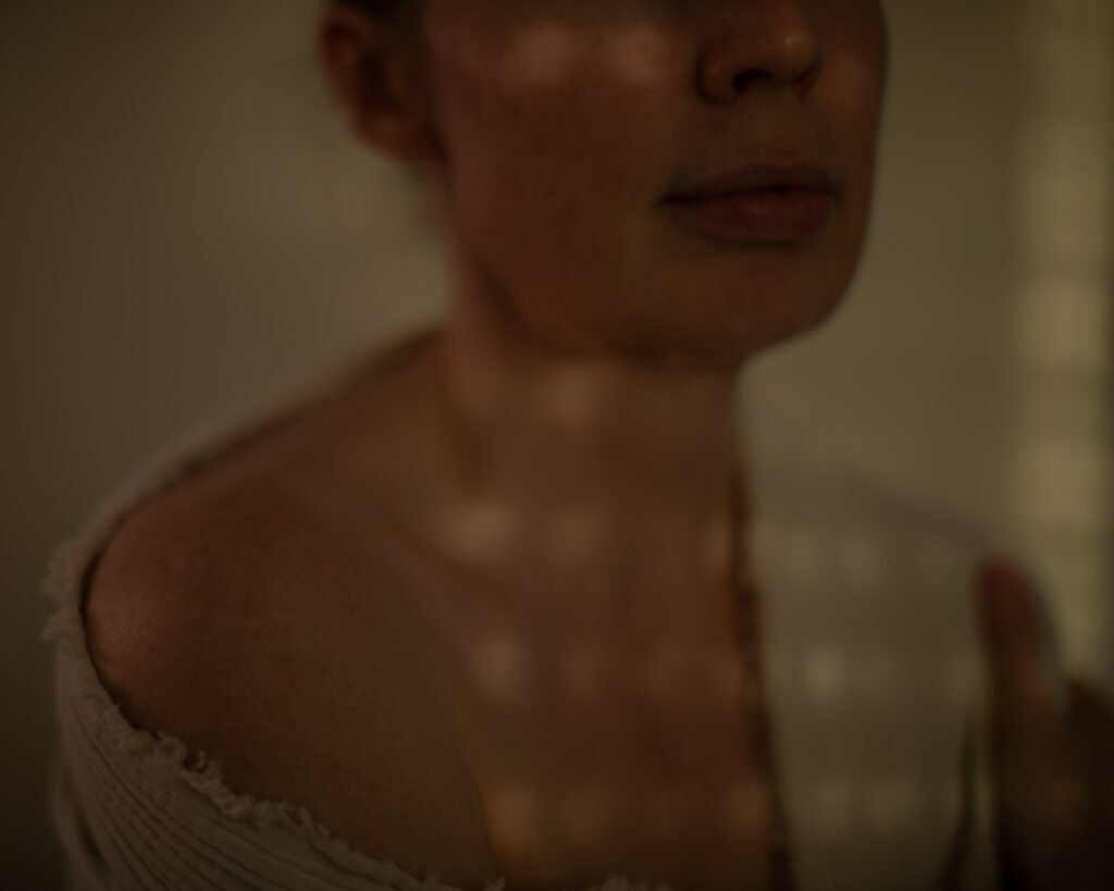 Soft close portrait with warm tactile light and quiet emotional atmosphere.